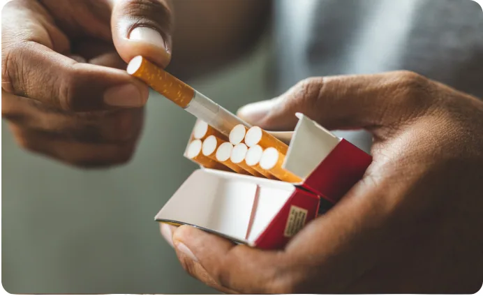 Hands taking a cigarette out of a packet